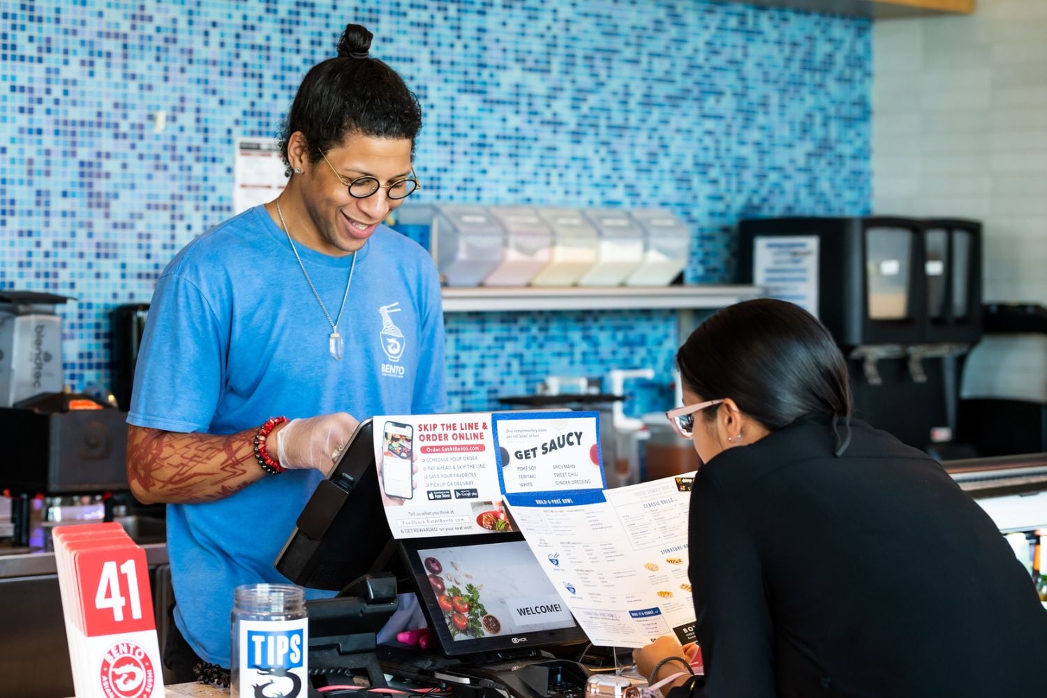 Bento worker greeting customer at POS